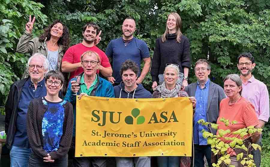 Photo of SJU ASA members at barbecue holding up the Academic Staff Association banner